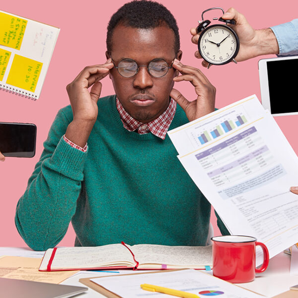 African american man sitting desk surrounded with gadgets papers 1 600x600
